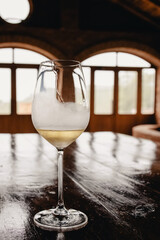 A glass of white wine on rustic wooden table