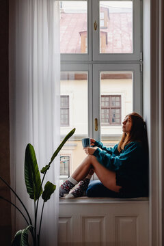 Woman sitting on the big windowsill