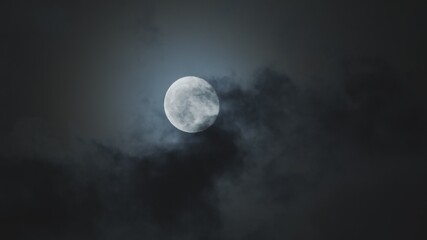 Naklejka na ściany i meble Full moon against cloudy night sky