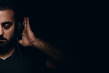 Fototapeta na wymiar International dj day bearded musician in headphones listen to music on black background