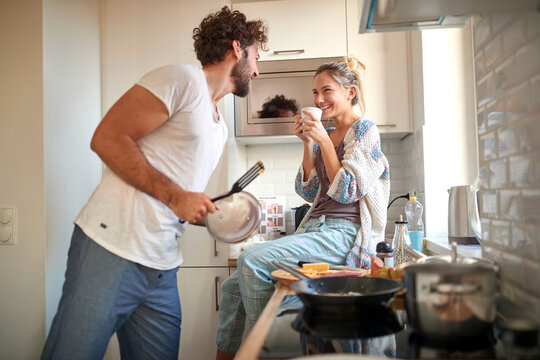 A young couple in love having good time while preparing a breakfast together. Cooking, together, kitchen, relationship
