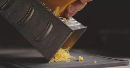 Grating cheddar cheese in natural light 120 fps slow motion footage