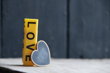 The word love made of yellow letters on a wooden background.
