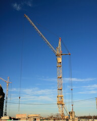 Fototapeta premium Tower cranes are working on the construction of a new house. Lifting crane.