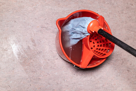 Top View Of Mop In Red Bucket With Dirty Water At Home