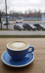 Macro photo cup of coffe cappuccino or late with hert on foam on wood tecture table in caffe. City...
