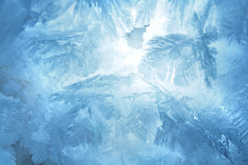 Fototapeta premium Abstract blue frozen pattern texture, frosted snowflakes close up background on the winter window 