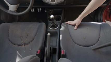 Man cleaning dirty car interior with vacuum cleaner