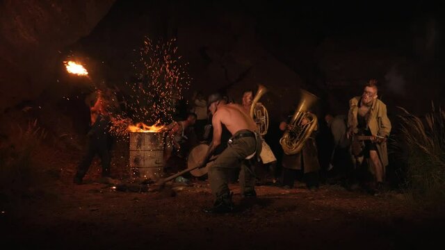 Crazy orchestra playing. Funny musicians play underground in a cave at night. Crazy people play musical instruments and dance funny dances in the cave. Funny bass guitarist, tubist, trumpeter, drummer