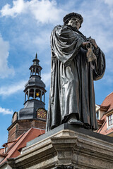 Fototapeta na wymiar Statute of Martin Luther in Market Square of Lutherstadt Eisleben in Saxony-Anhalt, Germany. Martin Luther was born in Eisleben in 1483 and died here in 1546.