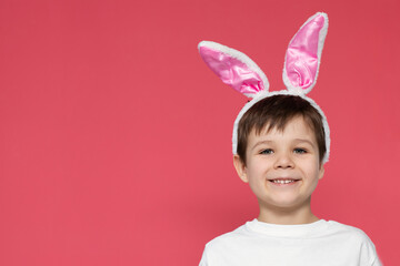 Cute little boy with bunny ears on a colored background. Easter holiday concept