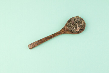 Wooden spoon on teal background top view