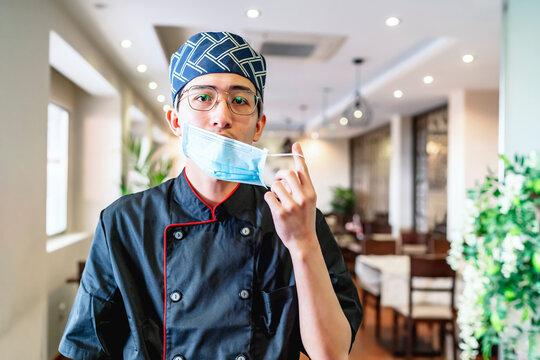 Japanese chef expert in sushi putting on mask
