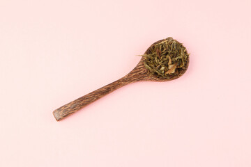 Wooden spoon on pink background top view