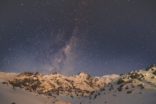 Milky Way above the illuminated mountain peaks at Whakapapa Ski Field, New Zealand