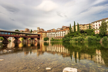 Fototapeta premium Cityscape of Bassano del Grappa with the Bridge of the Alpini (Ponte degli Alpini or Ponte Vecchio) and the Brenta River. Vicenza province, Veneto, Italy, Europe.
