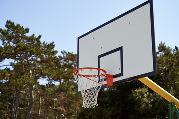 Outdoor basketball hoop or goal on blue sky background.