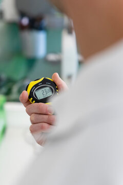 a physical trainer times a physical test, a stopwatch in hand