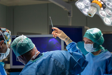 a surgeon sews up a patient in the operating room
