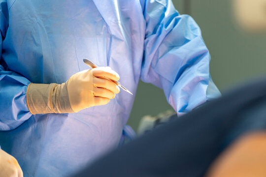 a surgeon holds a scalpel in his hand