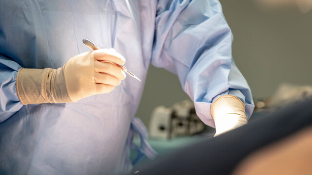 a surgeon holds his scalpel