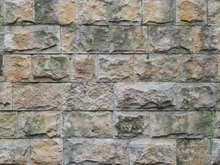 Wall with a rough textured cladding of spotty rectangular tiles. Not seamless texture