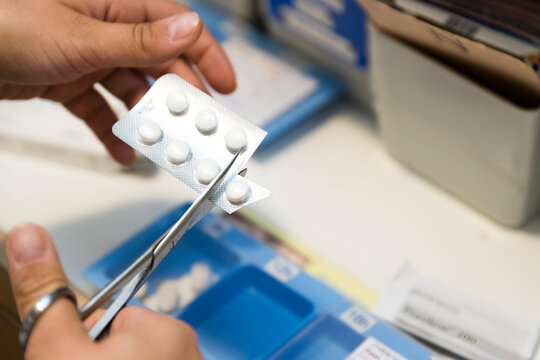 a nurse prepares a patient's pill organizer