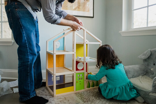 Father And Daughter Working Together To Build A Dollhouse