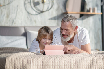 Happy smiling dad with baby with tablet