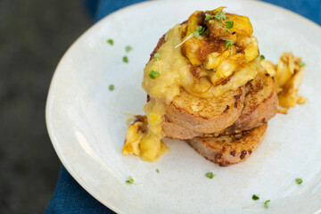Vegan french toasts with peanut butter, syrup and banana on a white plate.