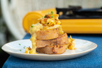 Vegan french toasts with peanut butter, syrup and banana on a white plate.