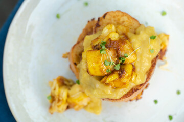 Vegan french toasts with peanut butter, syrup and banana on a white plate.