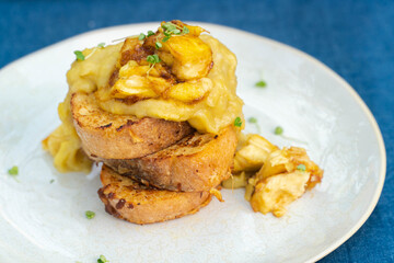 Vegan french toasts with peanut butter, syrup and banana on a white plate.