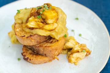 Vegan french toasts with peanut butter, syrup and banana on a white plate.