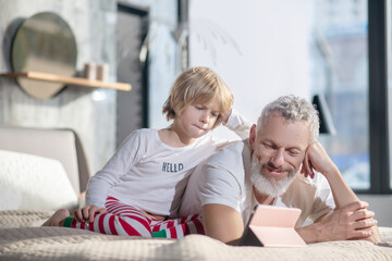 Father and child watching tablet together at home