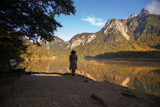 A person standing looking across a crystal clear lake in Germany