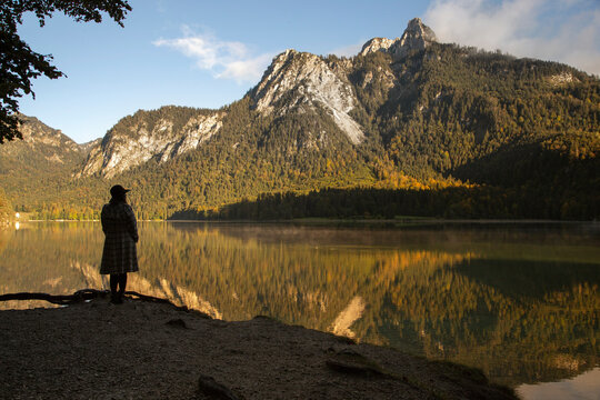 An anonymous person looking across a reflective lake in Germany
