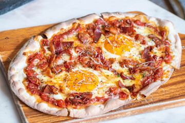 Ham and Eggs Breakfast style pizza on wooden platter