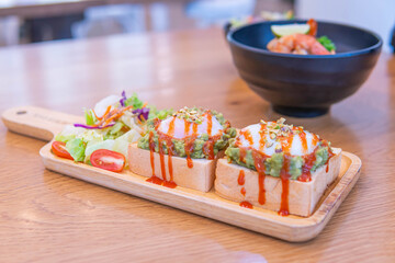 bread, avocado sauce, bacon, spinach, egg benedict on the white plate and old wood background, avocado sauce combine avocado and tomatoes, breakfast