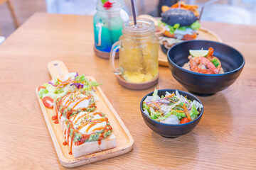 Dinner in cafe with eggs benedict, toast with avocado, pasta with shrimps and drinks