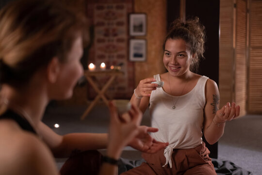 Cheerful woman with tea speaking with yoga instructor