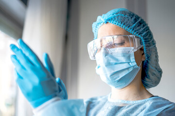 Medicine and Surgery theme: doctor putting on protective blue gloves
