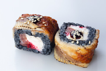 traditional Japanese cuisine. japanese sushi isolated on white background. maki sushi with eel, tomato, soft cheese (Philadelphia) and red caviar. black sushi