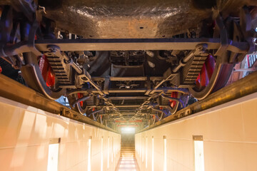 Wheels of an old locomotive train locomotive from below. View of the engine undercarriage from the bottom of the inspection pit.