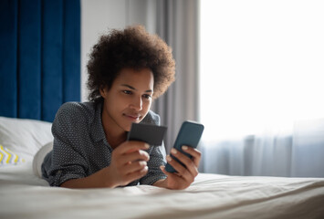 Black woman entering credit card credentials in smartphone