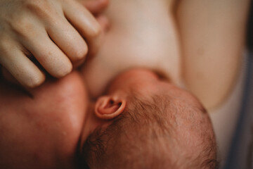 Close up of baby breastfeeding showing lots of skin