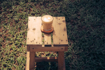 A cup of coffee on wooden table in garden