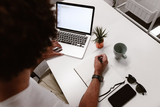 Young businessman using laptop at desk in coworking