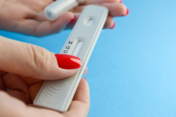 testing for antibodies. a blood test by a quantitative method to determine the coronavirus. girl with red nails is about to prick her finger. testing for IgG and IgM antibodies