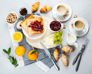 Delicious fresh breakfast served with drinks, croissants and fruits.